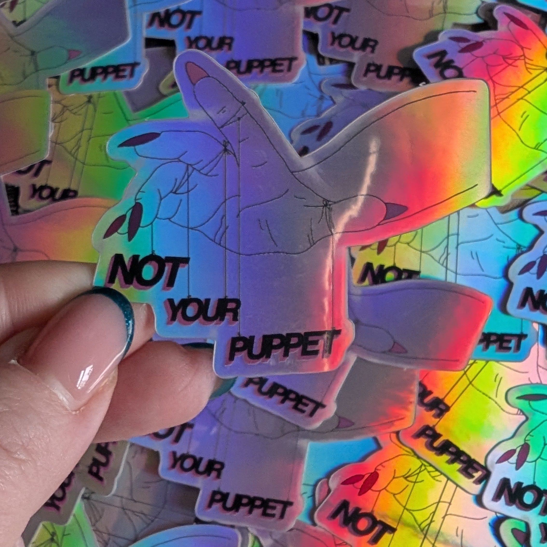 Holographic stickers with 'Not Your Puppet' text on a colorful background