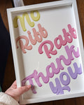 Framed sign with colorful text 'No Riff Raff Thank You' held by a person.